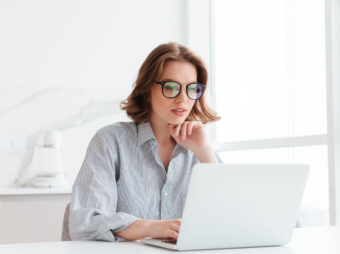 Charming businesswoman in glasses and striped shirt working with