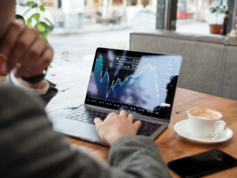 Cropped image of business man sitting by table in cafe
