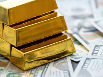 Gold bars above new 100 dollar banknotes. Saving concept