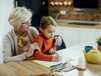 Little girl and her grandmother enjoying together while drawing