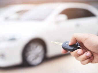 The salesman is opening and closing the car door with the key. F